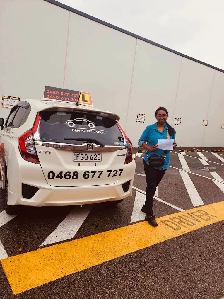 Female student in blue clothing with certificate at parking garage