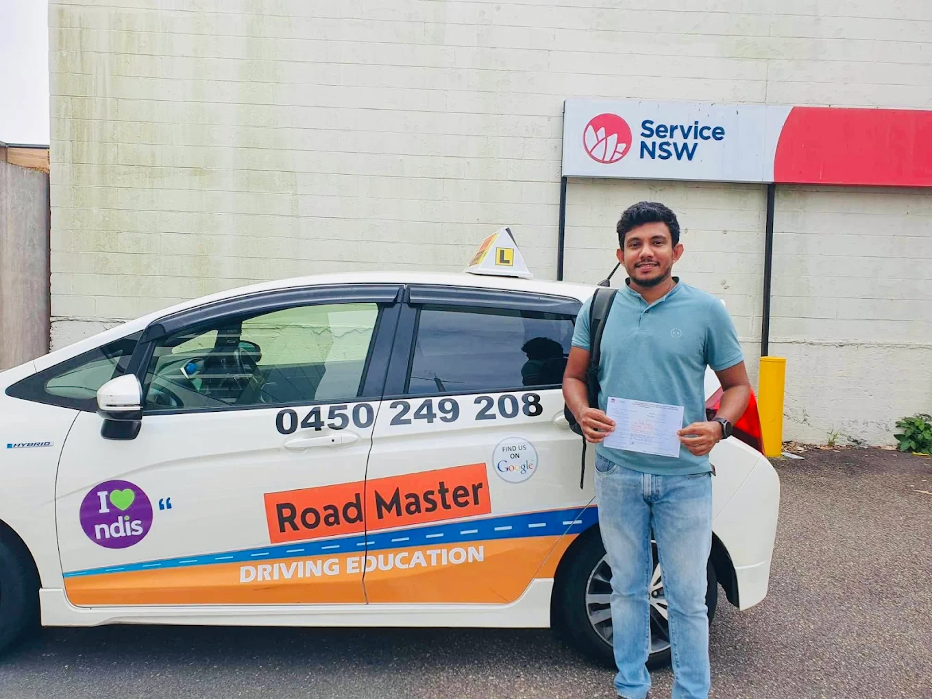 Male student in light blue polo with certificate at Service NSW