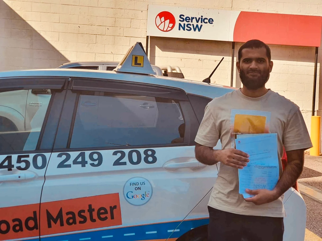 Male student in white t-shirt with certificate at Service NSW